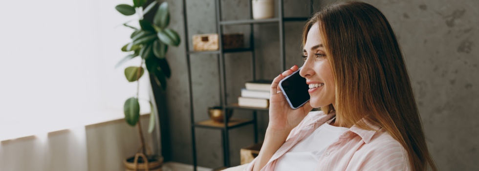 A woman talking on the phone at home.