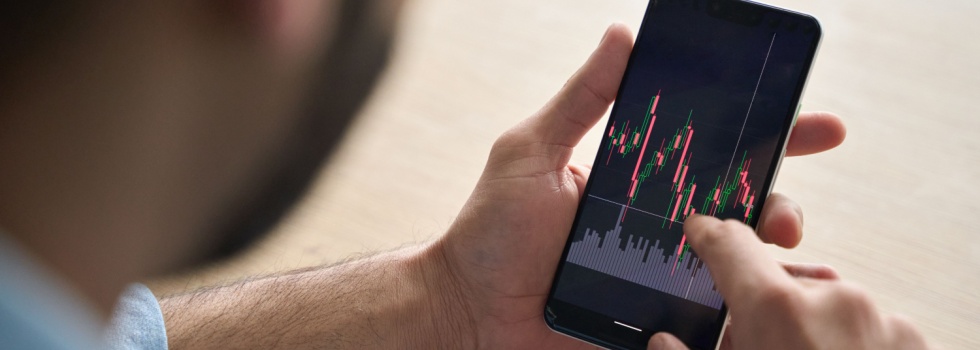 A man looking at investment performance on his phone.