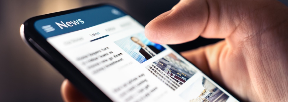 A person looking at a news feed on their phone.