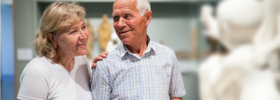 A couple looking at a statue in a museum.