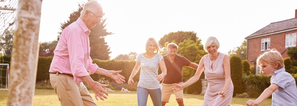 A family playing football in a garden.
