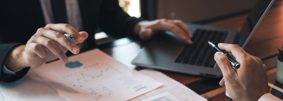 Two people analysing statistical reports.