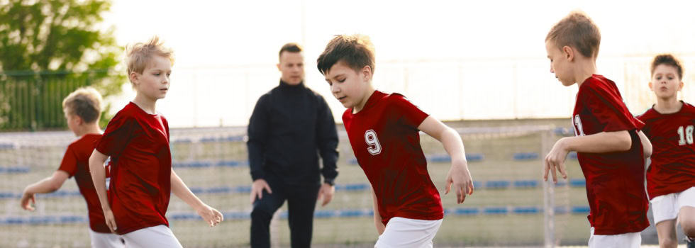 A children’s football coach watching a training session.