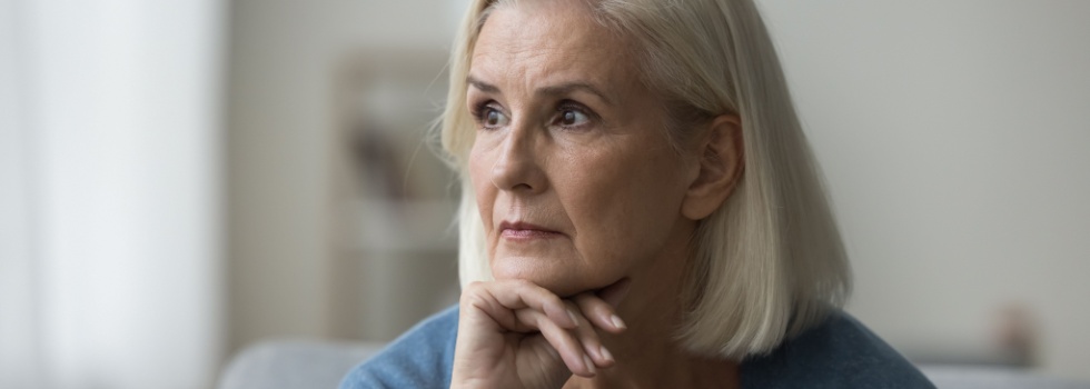 An older woman looks pensively off to one side.