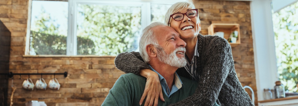 A couple hugging in their home.