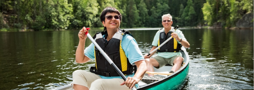 A couple on holiday taking a canoe ride.