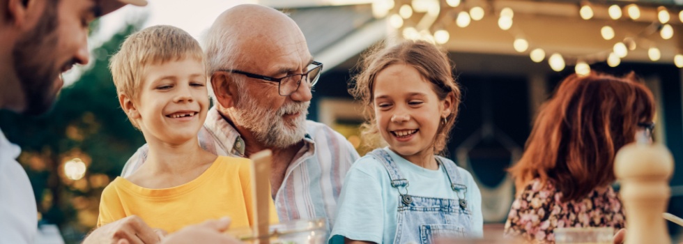 A grandfather laughing with his grandchildren.