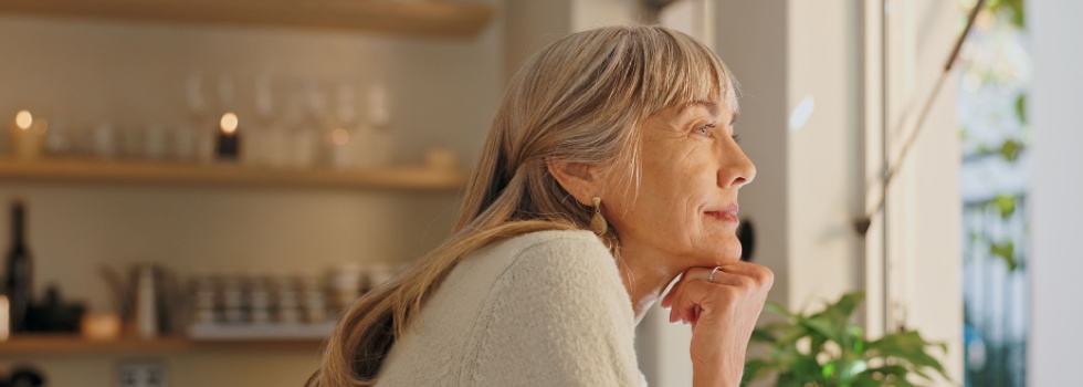 A woman looking out of the window at home.