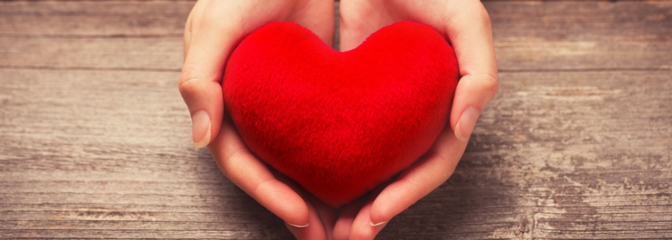 Close-up of hands holding a red heart