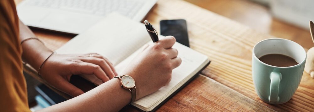 A woman making notes in a diary.