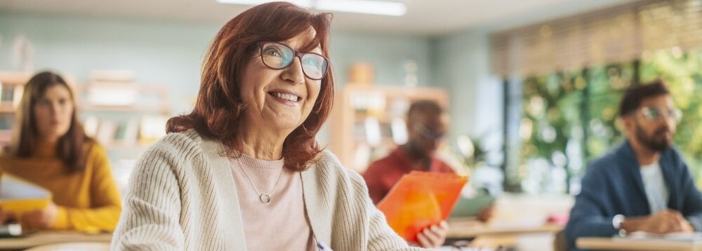 Happy senior woman taking notes in a classroom