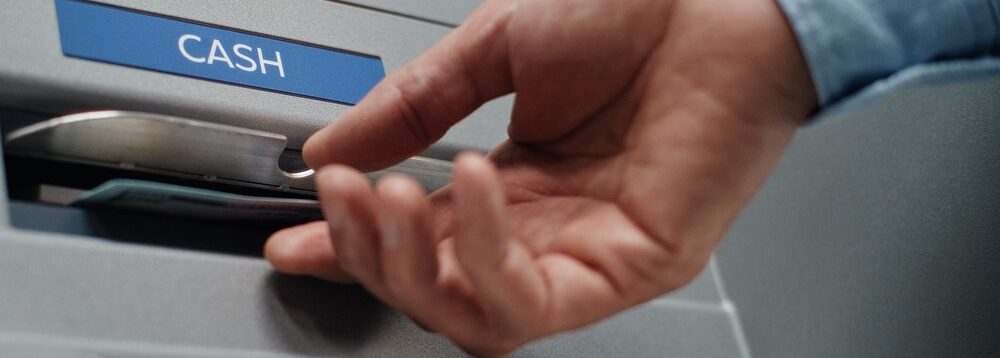 A person using an ATM to withdraw cash.