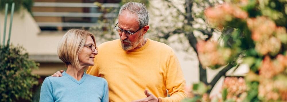 Mature couple walking outside a house