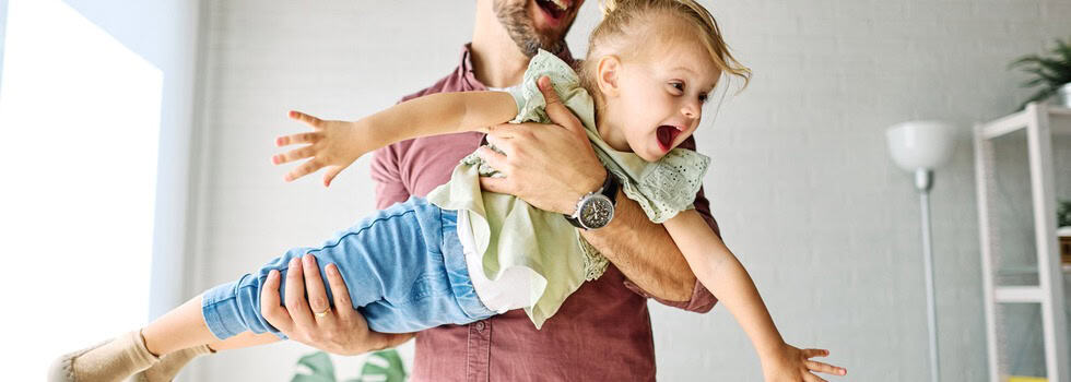 A father playing with his young daughter.