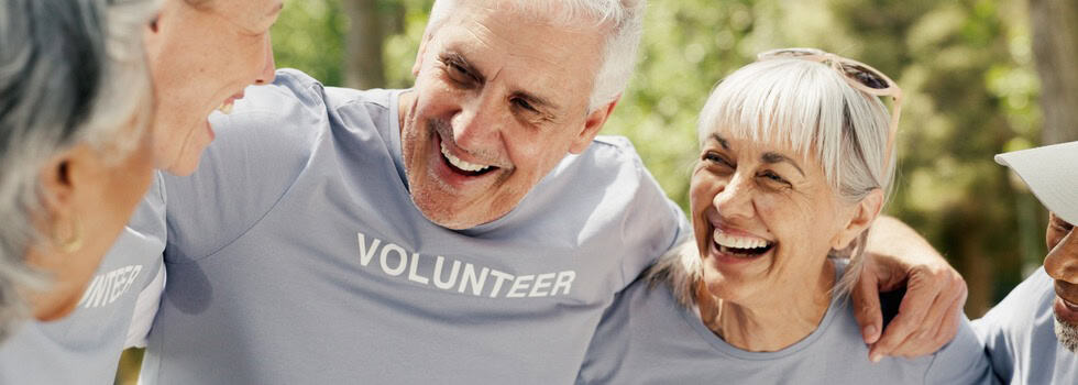 Happy senior people wearing “volunteer” t-shirts.
