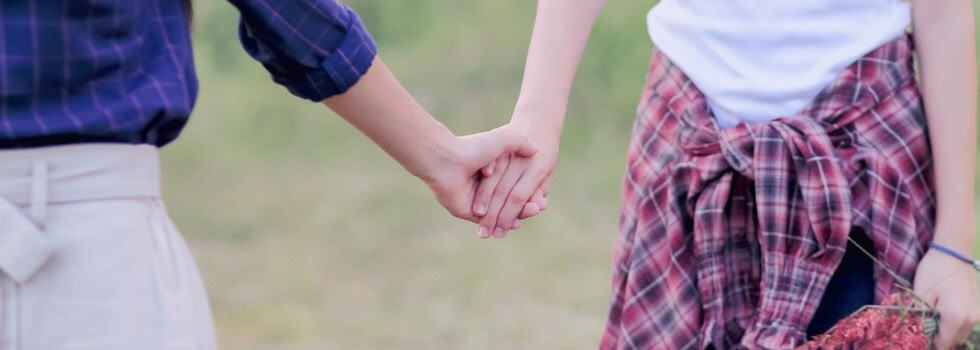 Two women holding hands.
