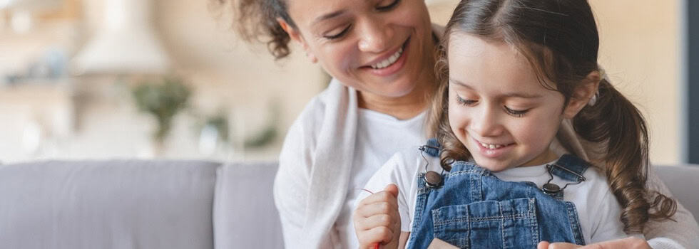 A mother and daughter unwrapping a gift.