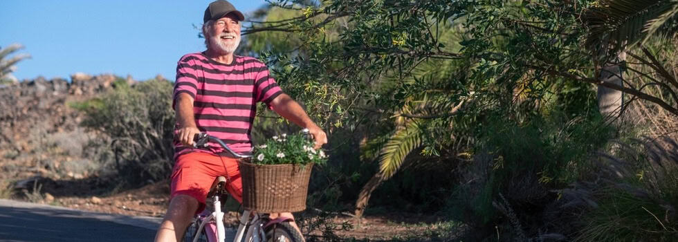 Happy senior man riding a bicycle.